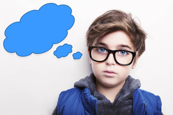 Thoughtful young boy wearing glasses with an empty thought bubble - Photo, Image