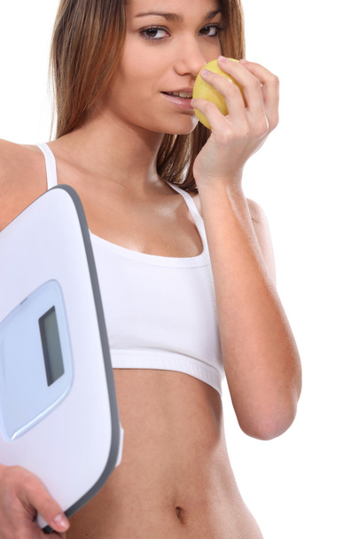 Woman with scales eating apple - Zdjęcie, obraz