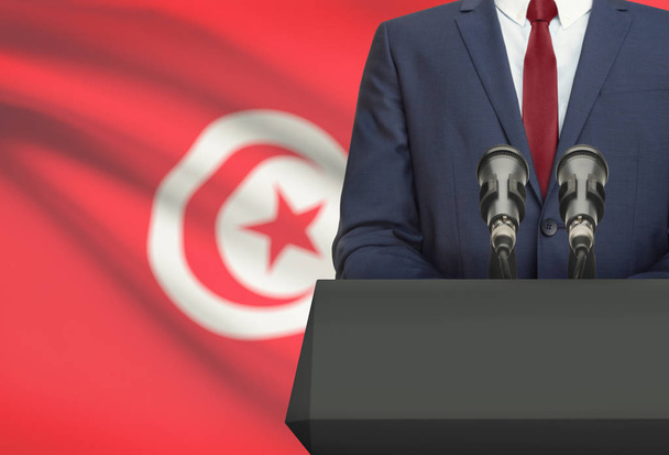 Businessman or politician making speech from behind a pulpit with national flag on background - Tunisia - Valokuva, kuva