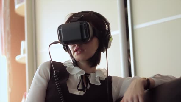 Mladá bruneta žena hraje hru pomocí Vr helmu pro chytré telefony. Rozšířená realita zařízení umožňuje hluboko do virtuálního prostoru - Záběry, video