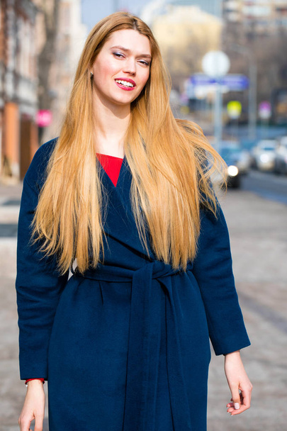 Portrait of a young beautiful woman in blue coat  - Fotó, kép