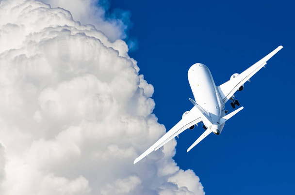 Летящий самолет в голубом небе и живописные облака
 - Фото, изображение