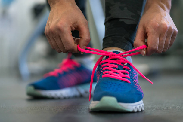 Buty do biegania - kobieta wiązanie sznurówki do butów. Kobieta, szykując się do  - Zdjęcie, obraz