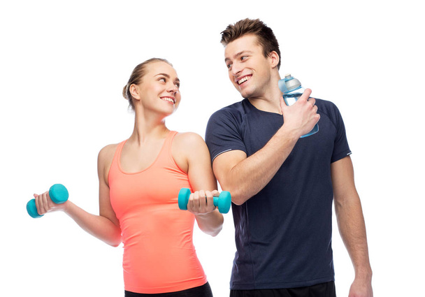 sportive man and woman with dumbbell and water - Fotografie, Obrázek