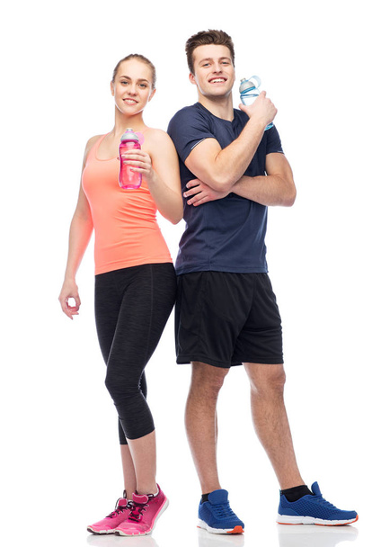 sportive man and woman with water bottles - Foto, Imagen