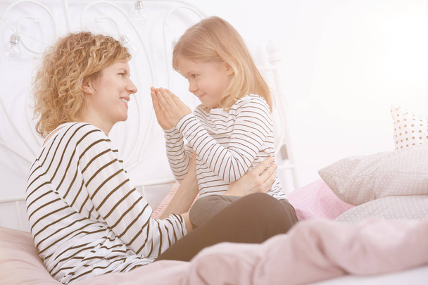 Mother and daughter on a bed - Foto, afbeelding
