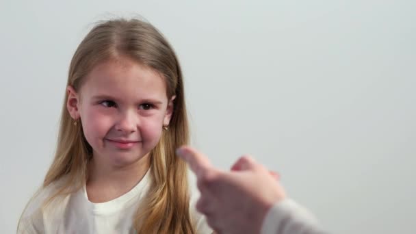 Un niño frustrado llora mientras mira la mano de un adulto. Una mano de adulto dirigida a la niña llorona
. - Metraje, vídeo