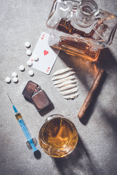 Overhead shot of hard drugs and alcohol on gray stone background - Fotoğraf, Görsel