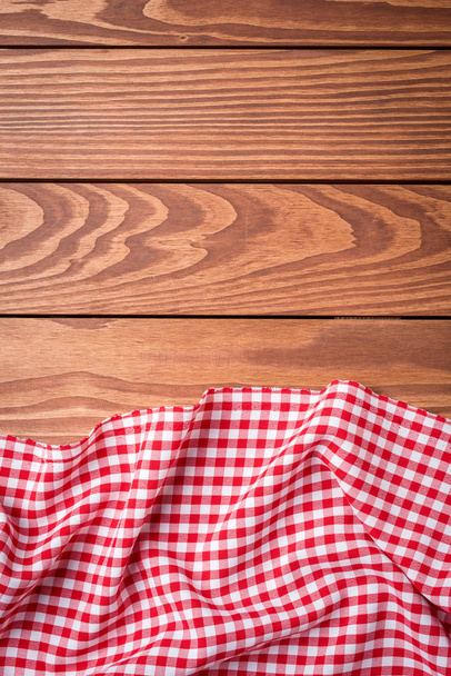Red folded tablecloth on wooden table - Foto, afbeelding