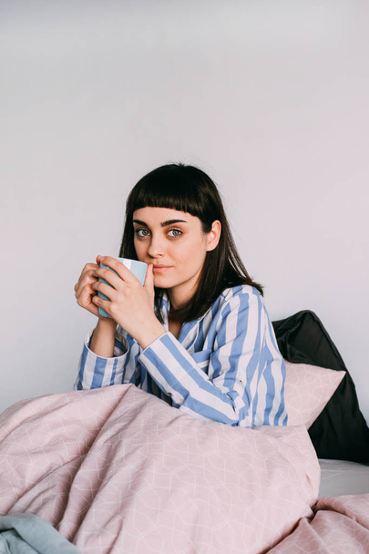 Hipster κορίτσι ξαπλωμένοι στο κρεβάτι με τον καφέ - Φωτογραφία, εικόνα