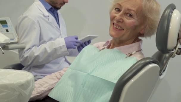 Kundin zeigt Daumen hoch auf dem Zahnarztstuhl - Filmmaterial, Video