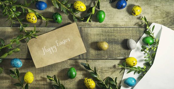 Huevos de Pascua en un sobre postal sobre un fondo de madera
 - Foto, imagen