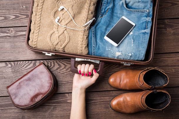 Ταξίδια έννοια παρασκευάσματα με ανοιχτό βαλίτσα και casual ρούχα της γυναίκας - Φωτογραφία, εικόνα