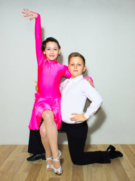 The young boy and girl posing at dance studio on gray. The ballroom dancing concept - Photo, Image