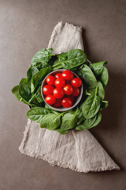 Washed fresh mini spinach and cherry tomatoes. Dark background. - Valokuva, kuva