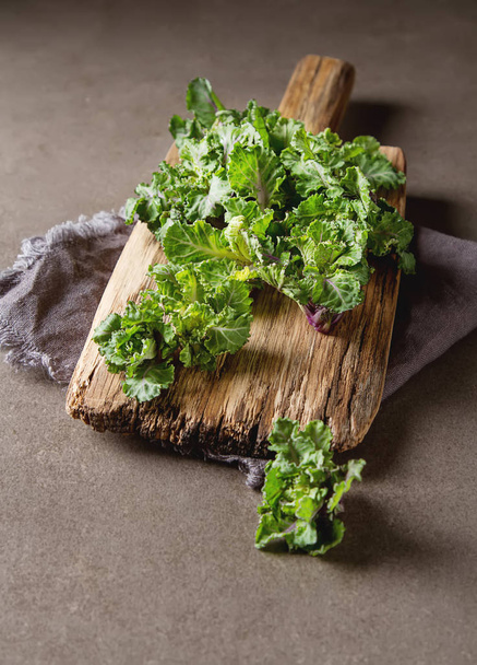 Fresh kale cabbage on a wooden board. Dark gray background. - Photo, image