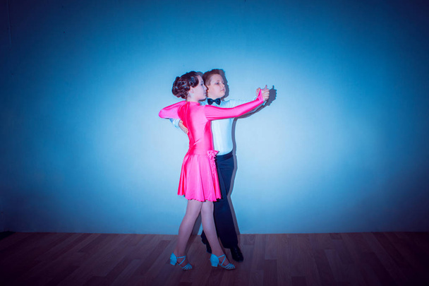 The young boy and girl posing at dance studio on gray. The ballroom dancing concept - Zdjęcie, obraz