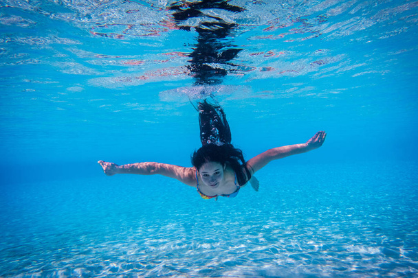 Girl dive with open eyes in the swimming pool - Foto, immagini