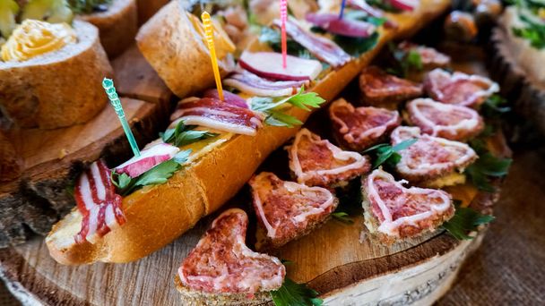 Tasty snacks and canape on a wooden board. Party concept. - Foto, Bild