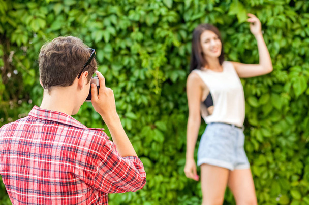 Photographer shooting beautiful brunette model near green wall. - Foto, immagini