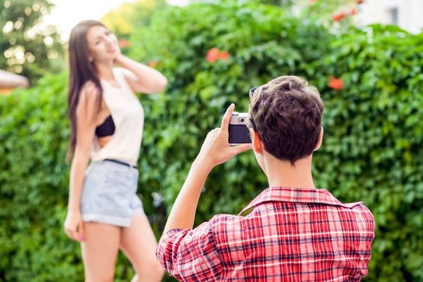 Photographer shooting beautiful brunette model near green wall. - Fotoğraf, Görsel