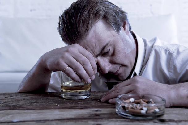 depressief alcoholische zakenman met losse stropdas verspild en dronken drinken van whisky - Foto, afbeelding