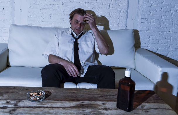 depressed alcoholic businessman with loose necktie wasted and drunk drinking whiskey - Фото, зображення