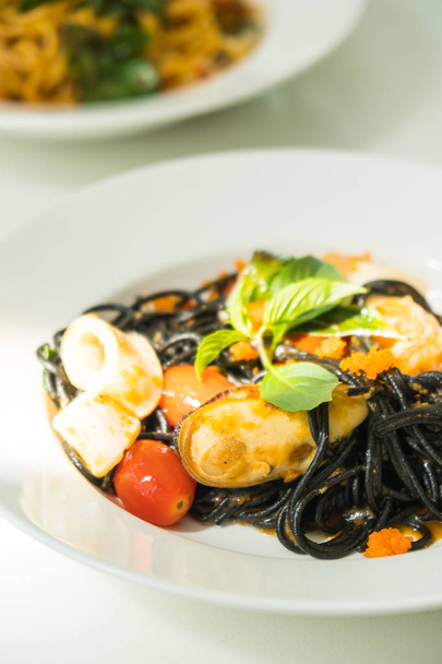 Fekete spagetti a tenger gyümölcsei fehér lemez - Fotó, kép