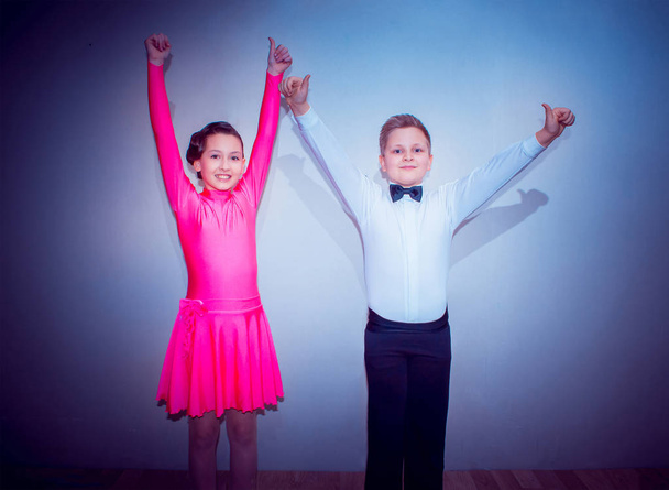 Το νεαρό αγόρι και το κορίτσι που θέτουν στο στούντιο χορού ως νικητές. Η έννοια του χορού - Φωτογραφία, εικόνα