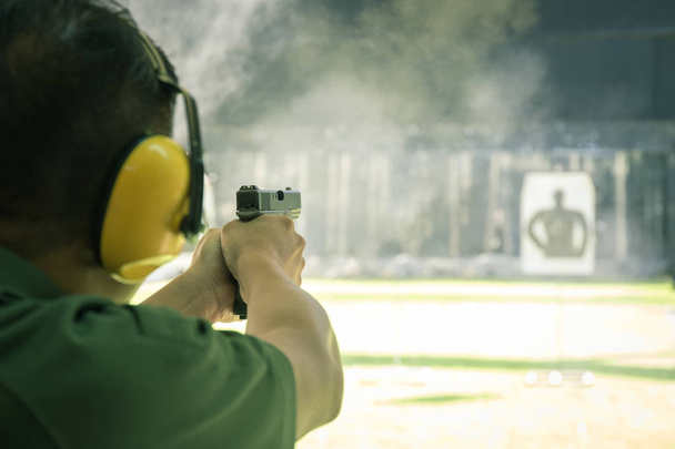 uomo tiro pistola automatica al bersaglio nel poligono di tiro
 - Foto, immagini