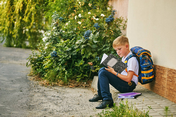 Porträt eines Schülers auf der Straße mit Rucksack und Notizbüchern - Foto, Bild