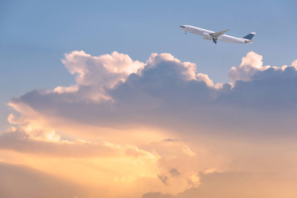 Verkehrsflugzeug fliegt über Himmel und Wolken bei Sonnenaufgang. - Foto, Bild