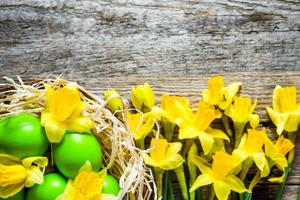 Easter background with daffodils and easter eggs in the basket - Foto, Imagem