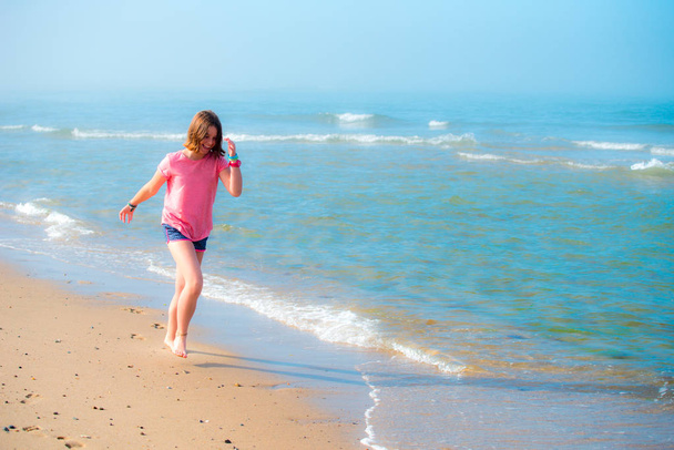 Girl runnoing along the coast line - Foto, imagen