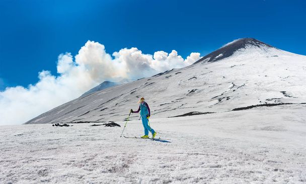 Girl ski touring under the top of the crater of Mount Etna - Photo, Image
