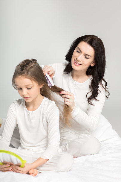 Madre peinando el cabello de la hija
  - Foto, imagen