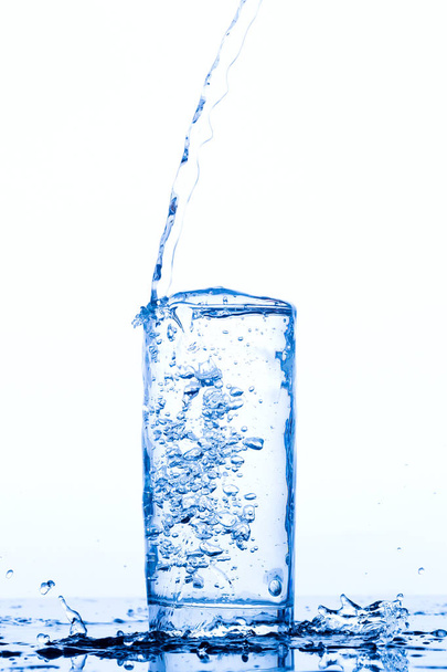 Glass with pouring drinking water - Φωτογραφία, εικόνα