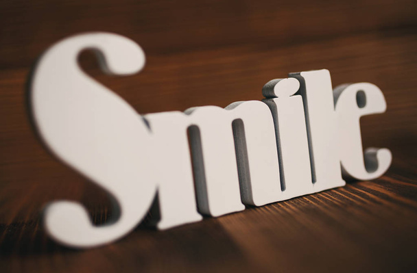 glimlach letters op houten achtergrond. - Foto, afbeelding