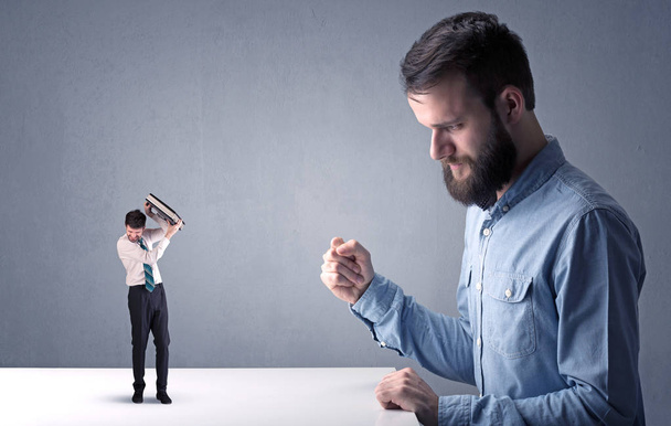 Jovem empresário lutando com empresário em miniatura
 - Foto, Imagem