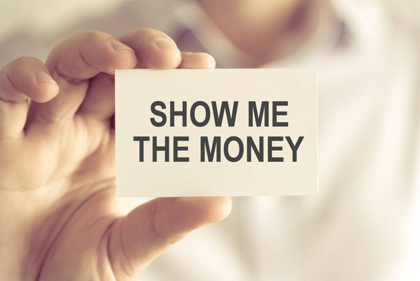 Empresário segurando Mostrar o cartão de mensagem de dinheiro
 - Foto, Imagem