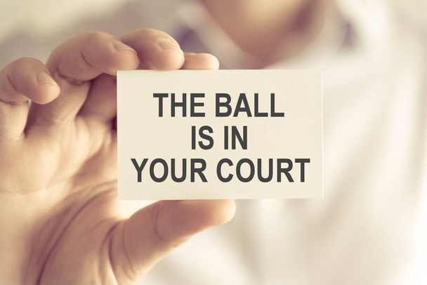 Businessman holding THE BALL IS IN YOUR COURT message card - Photo, Image