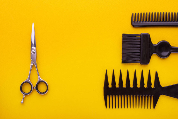 ножницы и расчески на желтой, парикмахерской концепции
 - Фото, изображение