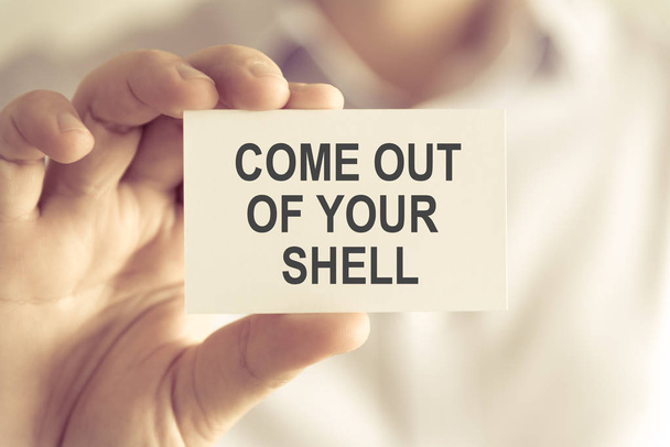 Бизнесмен, держащий COME out of your SHELL message card
 - Фото, изображение