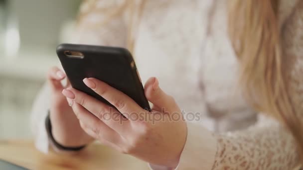 Κοντινό πλάνο του μια νεαρή γυναίκα στα χέρια, που κρατάει ένα smartphone. - Πλάνα, βίντεο