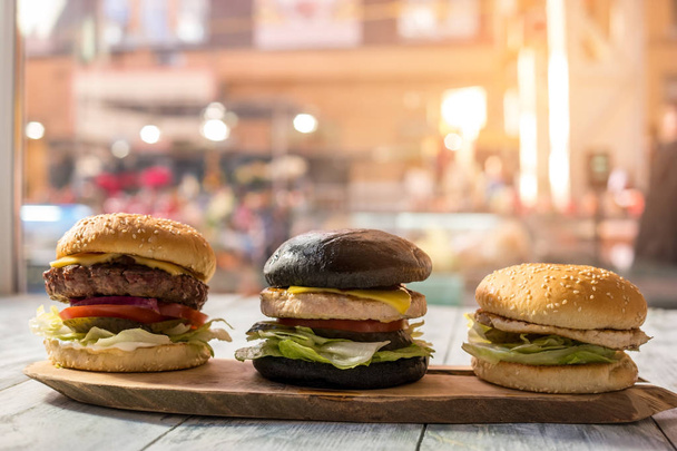 Tres hamburguesas sobre tabla de madera
. - Foto, imagen