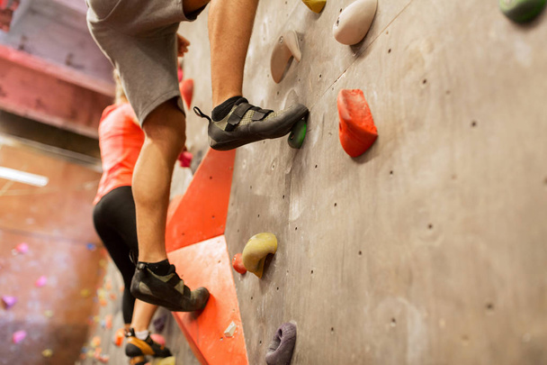 man and woman exercising at indoor climbing gym - Foto, afbeelding