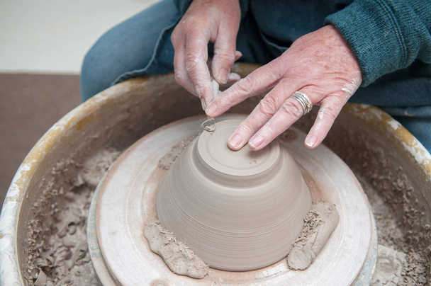 Fabrication de poterie avec des mains de femmes travaillant à la roue de poterie
 - Photo, image