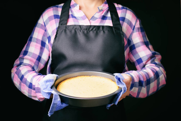 Tarta de queso recién horneada en manos de la mujer
 - Foto, Imagen