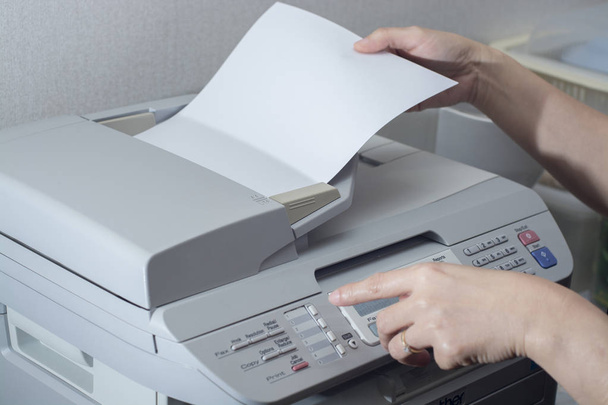 Midsection of businesswoman using fax machine in office - Photo, Image