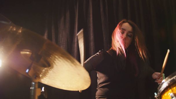wallendes schwarzes Haar - Beauty Girl spielt Schlagzeug-Rock in Garage - Foto, Bild